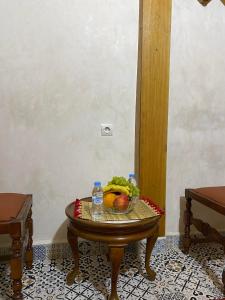 - une table avec un bol de fruits et de l'eau dans l'établissement RIAD Tamazouzt, à Essaouira