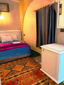 - une chambre avec un lit, une fenêtre et un tapis dans l'établissement RIAD Tamazouzt, à Essaouira