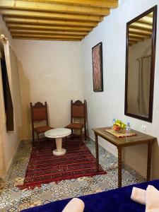 une chambre avec des chaises, une table et un miroir dans l'établissement RIAD Tamazouzt, à Essaouira