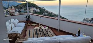 Un balcón con sofás y una mesa con vistas. en Villa Silvia, en Amalfi