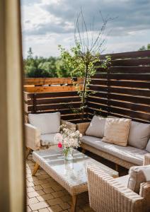 a patio with couches and a table with flowers on it at Apartamenty Hrube Niżne 23D in Zakopane