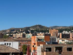 uma cidade com edifícios e montanhas ao fundo em Bonito apartamento en Granada (zona palacio congresos y metro) em Granada