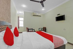 um quarto com uma cama grande e almofadas vermelhas em Super OYO Flagship Hotel Kanak International em Hyderabad