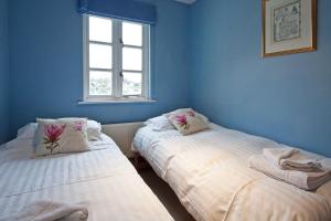 two beds in a room with blue walls and a window at Windrush Lake 89, Lodge View - P in South Cerney