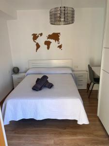 um quarto com uma cama branca e um mapa na parede em Bonito apartamento en Granada (zona palacio congresos y metro) em Granada