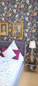 um quarto com uma cama e uma parede com flores em VILLA FREIA Dresden - Exklusive Ferienwohnung zum Erholen & Entspannen em Dresden