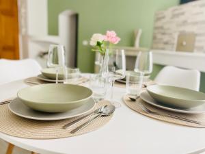 una mesa blanca con platos, tazones y copas de vino en Emi Relax B&B, en Castelmauro