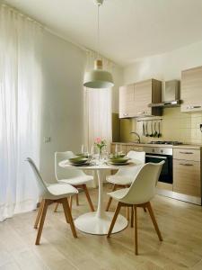 cocina con mesa blanca y sillas en Emi Relax B&B, en Castelmauro