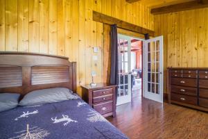 - une chambre avec un lit et un mur en bois dans l'établissement Le rocher - St-Adolphe, à Saint-Adolphe-d'Howard