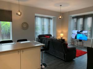 a living room with black chairs and a flat screen tv at Waterloo Sunset in Blackpool
