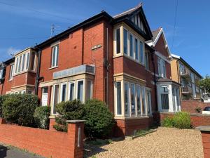 a red brick house with white windows on a street at Waterloo Sunset in Blackpool