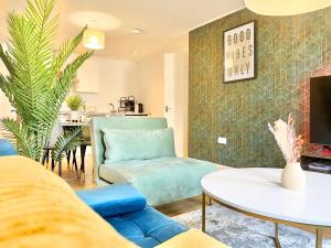 a living room with a blue couch and a table at 2 Modern Double Bed Apartment for 6 Guests By Hofin Stays Short Lets & Serviced Accommodation in London