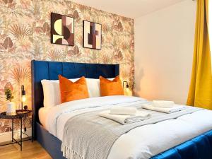a bedroom with a large blue bed with orange pillows at 2 Modern Double Bed Apartment for 6 Guests By Hofin Stays Short Lets & Serviced Accommodation in London