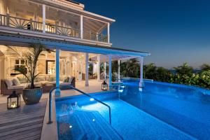 una villa con piscina y una casa en Hectors House Blue Sky Luxury, en Christ Church