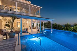 a villa with a swimming pool and a house at Hectors House Blue Sky Luxury in Christ Church