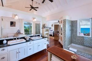 un baño con dos lavabos y una ducha en Hectors House Blue Sky Luxury, en Christ Church