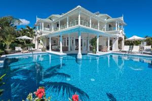 a large white house with a large swimming pool at Hectors House Blue Sky Luxury in Christ Church