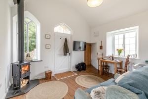 a living room with a couch and a fireplace at Hollocombe Chapel in Chulmleigh