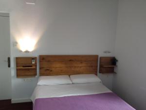 Schlafzimmer mit einem Bett mit einem Kopfteil aus Holz in der Unterkunft Cero estrellas Cabildo in Sanlúcar de Barrameda
