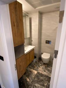 a bathroom with a white toilet and a sink and a toilet at New apartment with pool near the sea in Akbük