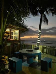 - une table et des chaises sur la plage avec un palmier dans l'établissement Treasure Cove Apartment, à Carles