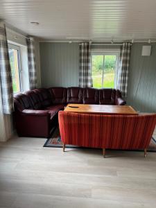 a living room with a couch and a coffee table at Fjellstad Gård - 2 minutes from E6 and 5 minutes drive from Steinkjer city in Steinkjer