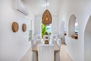 a dining room with white walls and a table and chairs at Exceptional Beachfront Living - Milord Sunsets home in Saint James