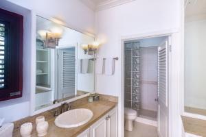 a white bathroom with a sink and a toilet at Exceptional Beachfront Living - Milord Sunsets home in Saint James +5 photos