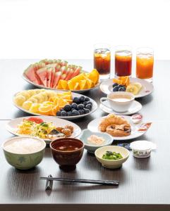 stół z wieloma talerzami jedzenia i napojów w obiekcie Hotel Sun w mieście Takasaki