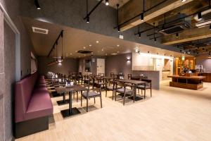 高崎Hotel Sun的一间带桌椅的餐厅和一间厨房