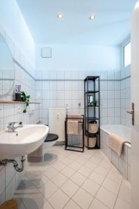a white bathroom with a tub and a sink and a bath tub at LE Vacation 3-Room-Apartment 67qm, Küche, Netflix, Free-TV in Schkeuditz