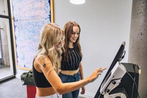two girls are standing next to a machine at Pod Hotel in Montreal