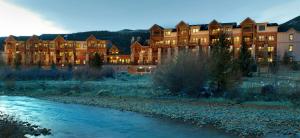 un gran edificio con un río delante de él en Mountain House by Keystone Resort, en Keystone