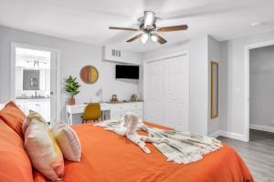 a bedroom with an orange bed with a ceiling fan at Baycation on Arch in Tampa