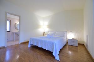 1 dormitorio blanco con 1 cama con manta azul en Villa Les Tortues, en Cattolica