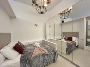 1 Schlafzimmer mit 2 Betten und einem Spiegel in der Unterkunft Exclusivo Piso Madrid Mendizabal in Madrid