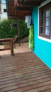 a wooden deck with a bench and a blue wall at Chalés Cerejeira in Visconde De Maua
