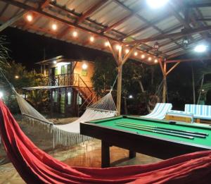 um grupo de redes de descanso com mesa de bilhar em Cayo Ecovillage em Puerto Cayo