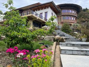 a house with flowers in front of it at Willing Resort, Trongsa in Kagha