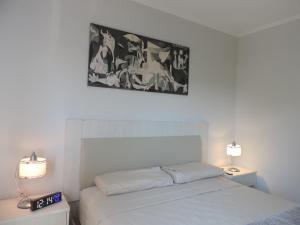 a bedroom with a white bed and two lamps at Departamento Confortable in Puerto Iguazú