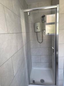 a bathroom with a shower with a glass door at Southsea Historic Gem - Elegant Apartments in Portsmouth +14 photos