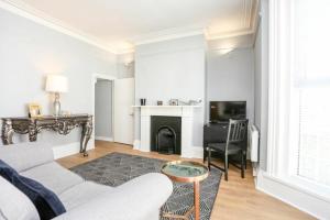 a white living room with a couch and a fireplace at Southsea Historic Gem - Elegant Apartments in Portsmouth