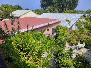 ein Haus mit rotem Dach und einigen Pflanzen in der Unterkunft Sunset Veli in Shaviyani Atoll