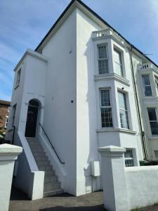 un edificio blanco con escaleras y una puerta en Southsea Historic Gem - Elegant Apartments, en Portsmouth