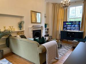 a living room with a couch and a television at The Regal at Penarth by MGroupSA in Cardiff