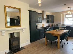 a kitchen with a wooden table and a stove at The Regal at Penarth by MGroupSA in Cardiff