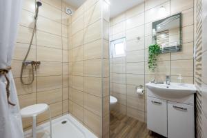 a bathroom with a sink and a shower at Białe Żagle - domki nad morzem in Kopań +36 photos