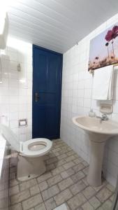 a bathroom with a blue door and a toilet and a sink at Suíte no Centro Histórico in Ouro Preto