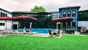 a house with a pool with chairs and umbrellas at Otantik Hotel & Spa in Bursa