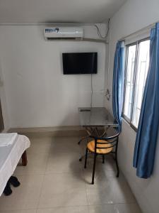 a room with a desk and a tv and a bed at Good Luck Hostel in Phnom Penh